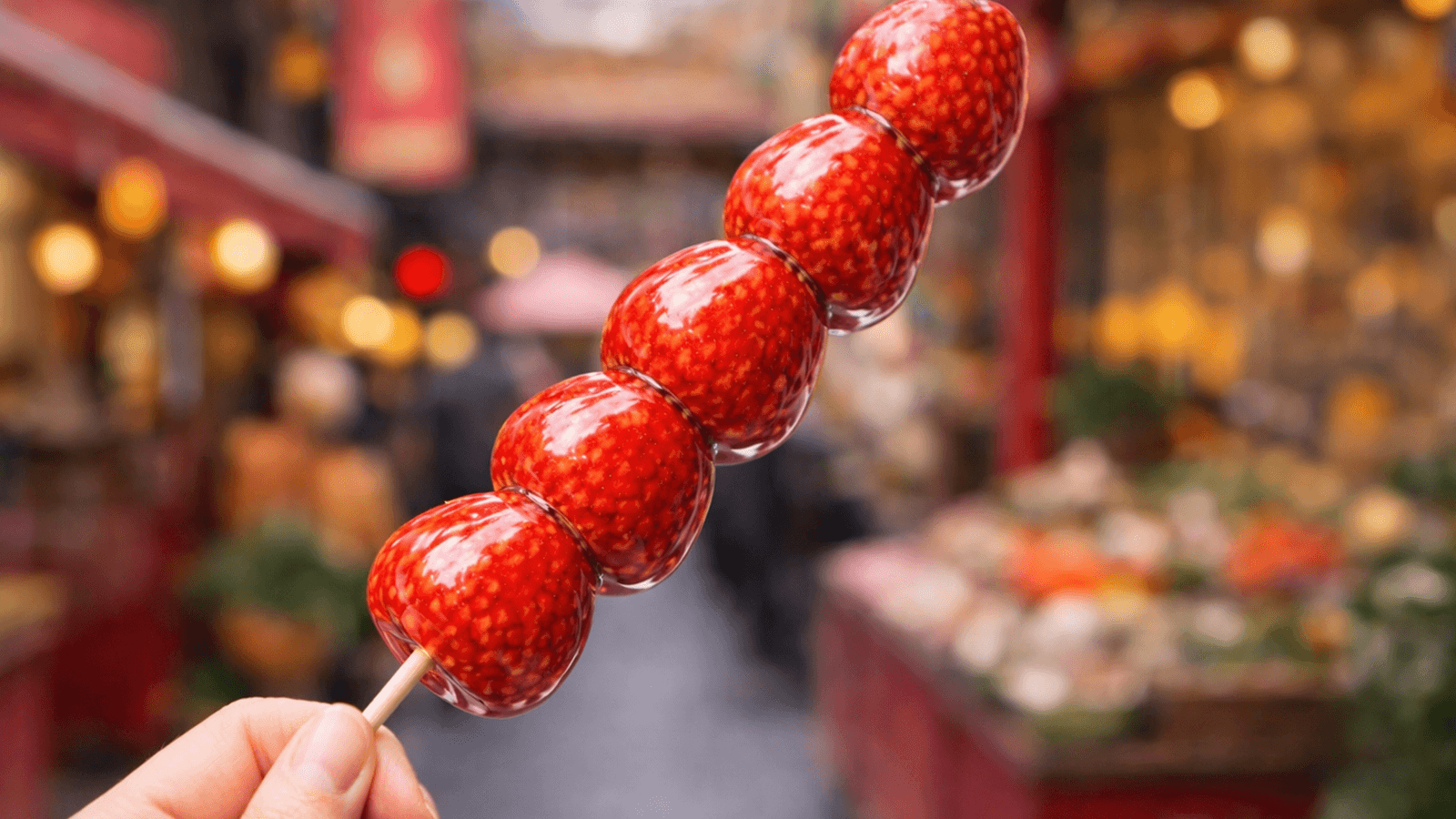 中華街でいちご飴を手に取る